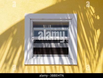 Finestra bianca sulla parete gialla Foto Stock