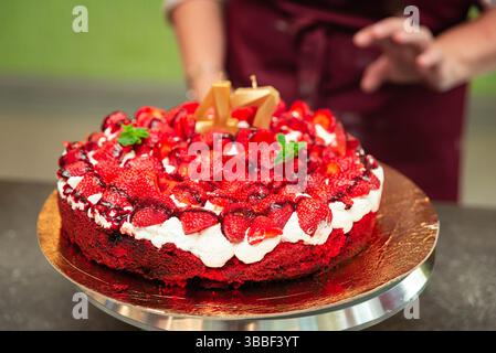 Torta di fragole natalizie con panna montata e frutti di bosco freschi, decorata con candele dorate per festeggiare il 47° compleanno. Foto Stock