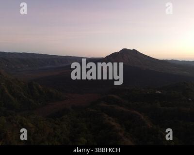 DefaultStunning drone shot del lago Batur all'alba, con sagome di montagna che si riflettono sull'acqua calma sotto un colorato cielo colpo di droni del lago B. Foto Stock