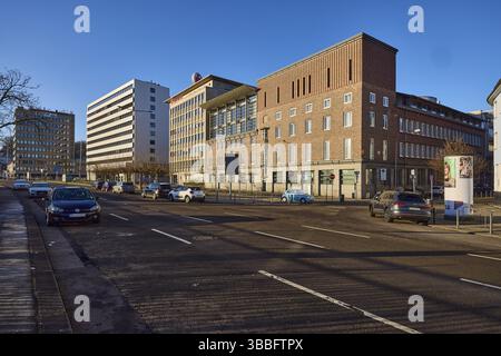 Architettura moderna, edificio in mattoni, sede centrale della Sparkasse Saarbruecken, HDI Haftpflichtverband der Deutschen industrie, parcheggio con veicoli, blu Foto Stock