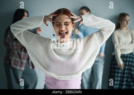 Giovane donna che si diverte e fa un gesto facciale divertente Foto Stock