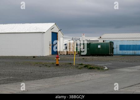 Akranes, Islanda - 15 maggio 2025: Cantiere industriale ad Akranes, Islanda con container, idrante antincendio e cieli ricoperti Foto Stock