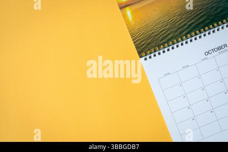 Pagina del calendario su sfondo giallo della tabella. Vista dall'alto. Copia spazio. Foto Stock