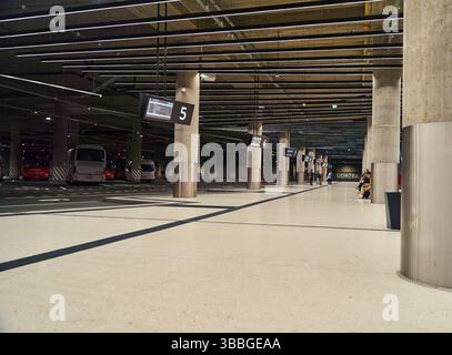 Una stazione degli autobus vuota all'interno con autobus parcheggiati e grandi colonne Foto Stock