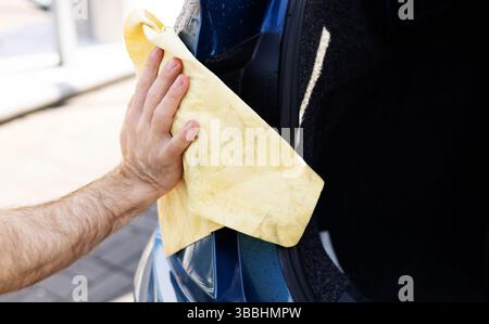 giovane uomo che lava la macchina Foto Stock