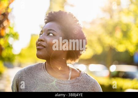 Sorridente giovane donna nel parco in una giornata di sole Foto Stock