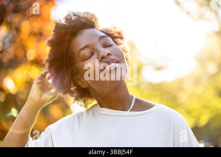 Sorridente giovane donna nel parco in una giornata di sole Foto Stock