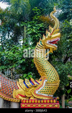 Statue di draghi colorate all'interno e all'esterno del tempio buddista Wat in Thailandia. Tradizionale architettura buddista religiosa tailandese con statue Foto Stock