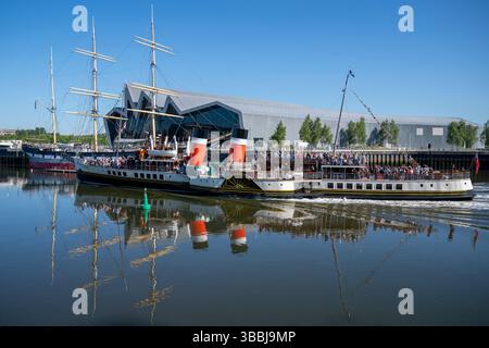 Il Waverley, l'ultimo piroscafo a pale al mondo, passa davanti al Glenlee Highship e al Riverside Transport Museum mentre si fa strada lungo il fiume Clyde durante la prima navigazione dell'anno. Il Waverley fu costruito nel 1945, originariamente per il percorso verso Loch Goil e Loch Long da Craigendoran & Arrochar nella Scozia occidentale. Ora visita diverse aree del Regno Unito offrendo viaggi regolari durante i mesi estivi. Data foto: Venerdì 16 maggio 2025. Foto Stock