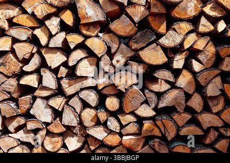 Una pila di legna da ardere tritata ben impilata. Sfondo o texture naturali, per prepararsi all'inverno. Foto Stock
