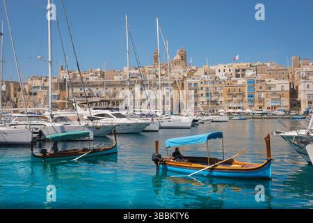 Porto di Vittoriosa, vista da Vittoriosa verso la città sul lungomare di Isla con i traghetti (dghajsa) e gli yacht ormeggiati a Dockyard Creek, Malta Foto Stock