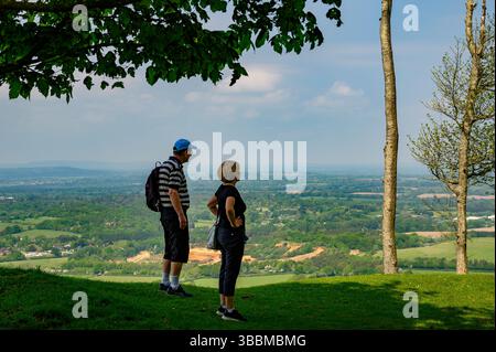 Una coppia ammira la vista sul Sussex Weald dal bastione del Chanctonbury Ring preistorico nel West Sussex, in Inghilterra. Foto Stock