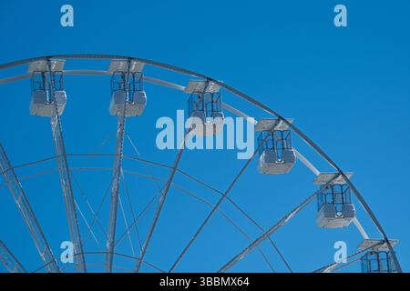 Un'impressionante ruota panoramica bianca si erge su un cielo blu limpido Foto Stock