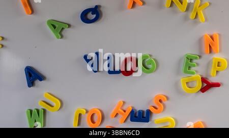 Lettere magnetiche colorate "vlog" su una lavagna in legno in aula o in sala giochi. Foto Stock