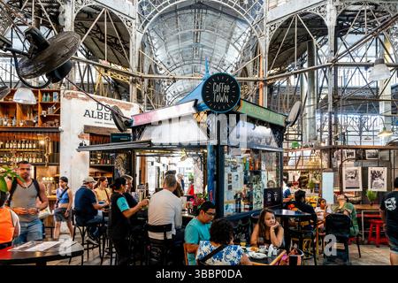 Turisti e gente del posto seduti a mangiare in Un Cafe all'interno del Mercado De San Telmo, San Telmo, Buenos Aires, Argentina. Foto Stock