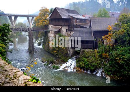 Rastoke Croazia. 8 ottobre 2015. Mulini panoramici lungo il fiume e vecchi edifici in legno sopra le acque a cascata con ponti sullo sfondo Foto Stock