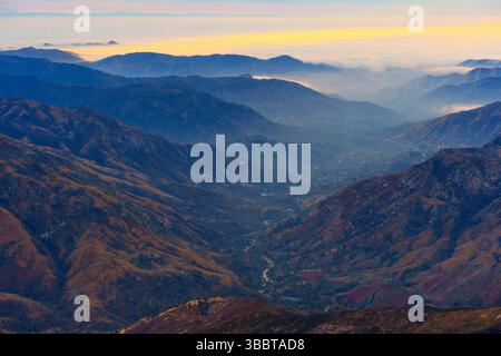 Vista aerea mozzafiato delle nebbiose valli del Sequoia National Park, che mostra i profondi canyon e le catene montuose a strati all'alba. Foto Stock