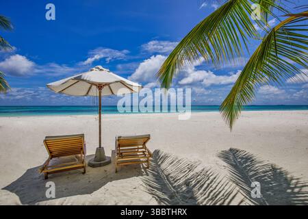 Spiaggia tropicale con sedie luminose e ombrelloni sulla spiaggia sabbiosa dell'isola paradisiaca, perfetta per vacanze di piacere e relax Foto Stock