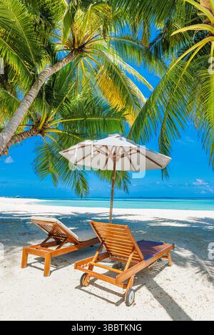 Spiaggia soleggiata da sogno sedie ombrellone sulla sabbia romantica coppia sotto le foglie di palma amore destinazione panoramica costa tropicale paesaggio vacanze estive Foto Stock