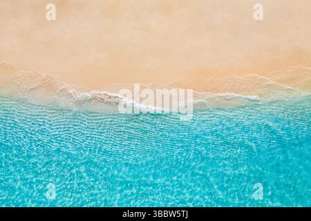 Soleggiata spiaggia di sabbia dorata con onde tranquille lungo la tranquilla costa del mare, vista aerea dell'esotico paesaggio tropicale mediterraneo marino Foto Stock