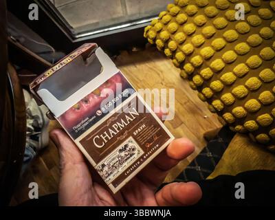 BELGRADO, SERBIA - 22 MARZO 2025: confezione di sigarette marroni Chapman con avvertenza sulla salute, testo e logo russi, con confezione di tabacco e anti-smo Foto Stock