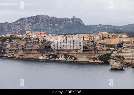 20 aprile 2025, Francia, Bonifacio: Veduta della città di Bonifacio sull'isola di Corsica (Francia) il 20.04.2025. Potrai vedere il centro storico medievale (Ville haute (città alta)) su un promontorio di pietra calcarea e arenaria, che degrada verticalmente verso il mare in gran parte, e la cosiddetta scalinata del re d'Aragona. Bonifacio (corso Bunifaziu; Ligure Bunifazziu o Bonifacio) è una città portuale situata nel sud dell'isola francese del Mediterraneo della Corsica (Corsica) nel dipartimento della Corsica del Sud. Situata su un altopiano roccioso simile a una penisola, la città vecchia è una delle più belle dell'isola Foto Stock