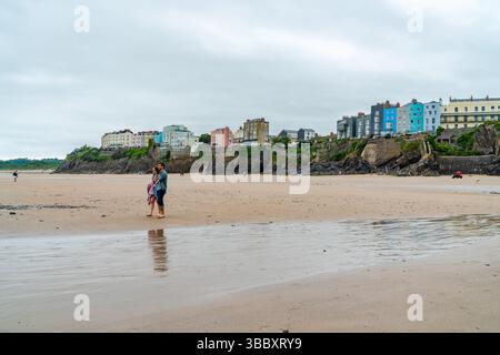 TENBY, GALLES - 28 GIUGNO 2021: La gente passeggia lungo una spiaggia di sabbia a Tenby, nel Galles del sud-ovest. Foto Stock