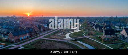 Una splendida vista ad alto angolo di Nijkerk la mattina presto, dove sentieri tortuosi collegano case lungo le rive di un fiume sereno e fluente. Uno stunni Foto Stock
