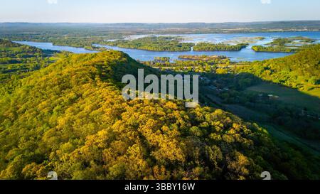 Vista aerea dall'Apple Blossom Overlook Park che mostra verdi colline ondulate e il fiume Mississippi al tramonto, con un cielo scintillante e un paesaggio tranquillo. Foto Stock