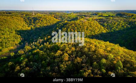 Vista aerea dall'Apple Blossom Overlook Park che mostra colline verdi ondulate e terreni agricoli al tramonto con luce dorata sul paesaggio rurale del Wisconsin. Foto Stock