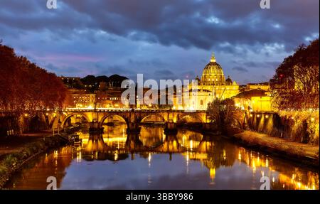 Splendida immagine della Basilica di San Pietro, del Ponte Sant'Angelo e del Tevere nella notte buia a Roma, Italia. Ponte Sant'Angelo e cattedrale di San Pietro Foto Stock