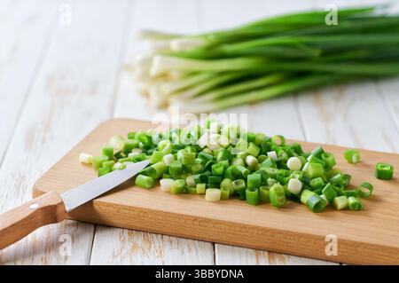 tagliere con cipolle elastiche sul tavolo, messa a fuoco selettiva. Foto Stock