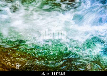 Acqua selvaggia che scorre sopra e tra rocce rocciose con l'energia grezza del torrente di montagna della Glenmalure Valley. Foto Stock