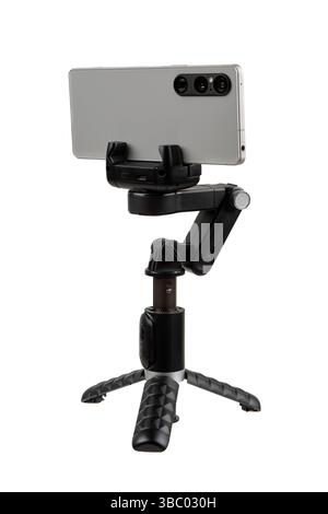 Smartphone montato con orientamento orizzontale su treppiede compatto stabilizzatore cardanico, isolato su sfondo bianco. Foto Stock