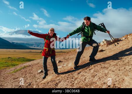 Escursionisti uomini e donne che scendono dalla roccia sullo sfondo del cielo Foto Stock
