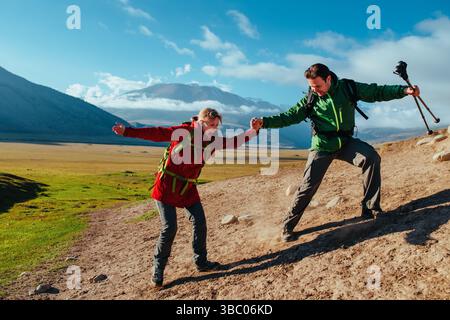 Escursionisti uomini e donne che scendono dalla roccia sullo sfondo del cielo Foto Stock