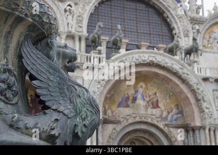 Antico ornamento di strada con leoni alati e basilica di San Marco sullo sfondo, in San Piazza Marco, famosa attrazione turistica a Venezia, Italia. Selezionare Foto Stock