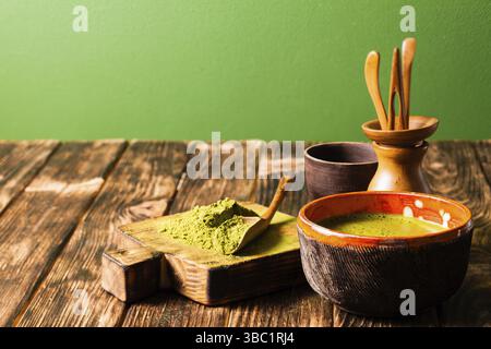 Matcha polvere di tè e matcha bere in una ciotola sul tavolo, copiare lo spazio Foto Stock