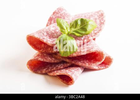 Tagliare le fette di salame freddo primo piano isolato su bianco Foto Stock
