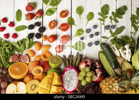 Composizione di vari ortaggi e frutti tagliati. Cumulo di verdure e frutta su sfondo bianco di legno Foto Stock