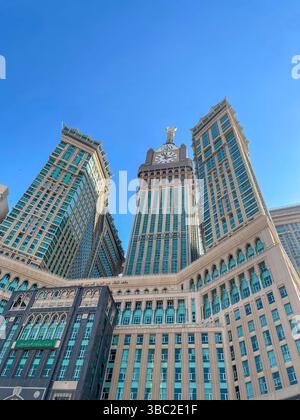 La torre dell'orologio della Mecca risplende in modo luminoso sotto il cielo del deserto alla luce del sole. Questa foto è stata scattata dalla Mecca, Arabia Saudita. Foto Stock