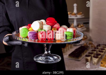 Macaron colorati e altri dessert serviti sul tavolo. Servizio catering Foto Stock