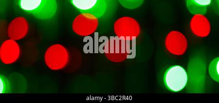 Sfondo astratto sfocato con cerchi bokeh rossi e verdi luminosi su sfondo scuro Foto Stock