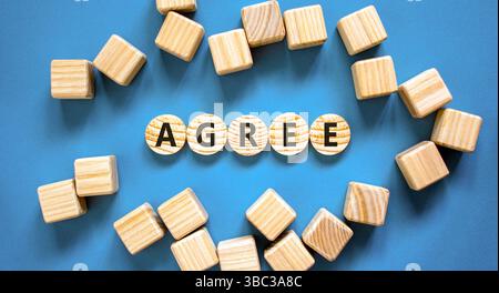Simbolo di accordo. La parola concettuale è d'accordo su bei cerchi di legno. Splendido sfondo blu da tavolo. Bellissimi cubetti di legno. Il concetto di business è d'accordo. Co Foto Stock