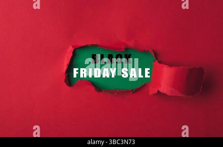Sfondo rosso con un buco verde. Il buco è circondato dalle parole Black Friday sale Foto Stock