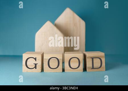 Blocco di legno con sopra la parola "BUONO". Ci sono quattro blocchi in totale. I blocchi sono impilati uno sopra l'altro Foto Stock