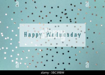Sfondo blu con molte stelle e le parole Happy Wednesday scritte in bianco. Le stelle sono sparse su tutto lo sfondo Foto Stock