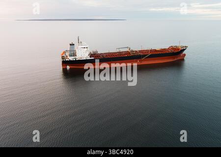 Grande petroliera in mare aperto: Colpo aereo di una nave da carico in acque calme sotto un cielo coperto. Foto Stock