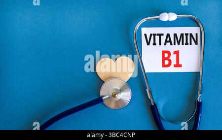Simbolo della vitamina B1. Parole concettuali vitamina B1 su bella carta bianca. Cuore in legno e stetoscopio. Bellissimo sfondo blu. Stile di vita sano medico Foto Stock
