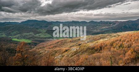 Valle del fiume Reno in un giorno nuvoloso della stagione autunnale. Badlands in primo piano. Città metropolitana di Bologna, Emilia-Romagna, Italia Foto Stock